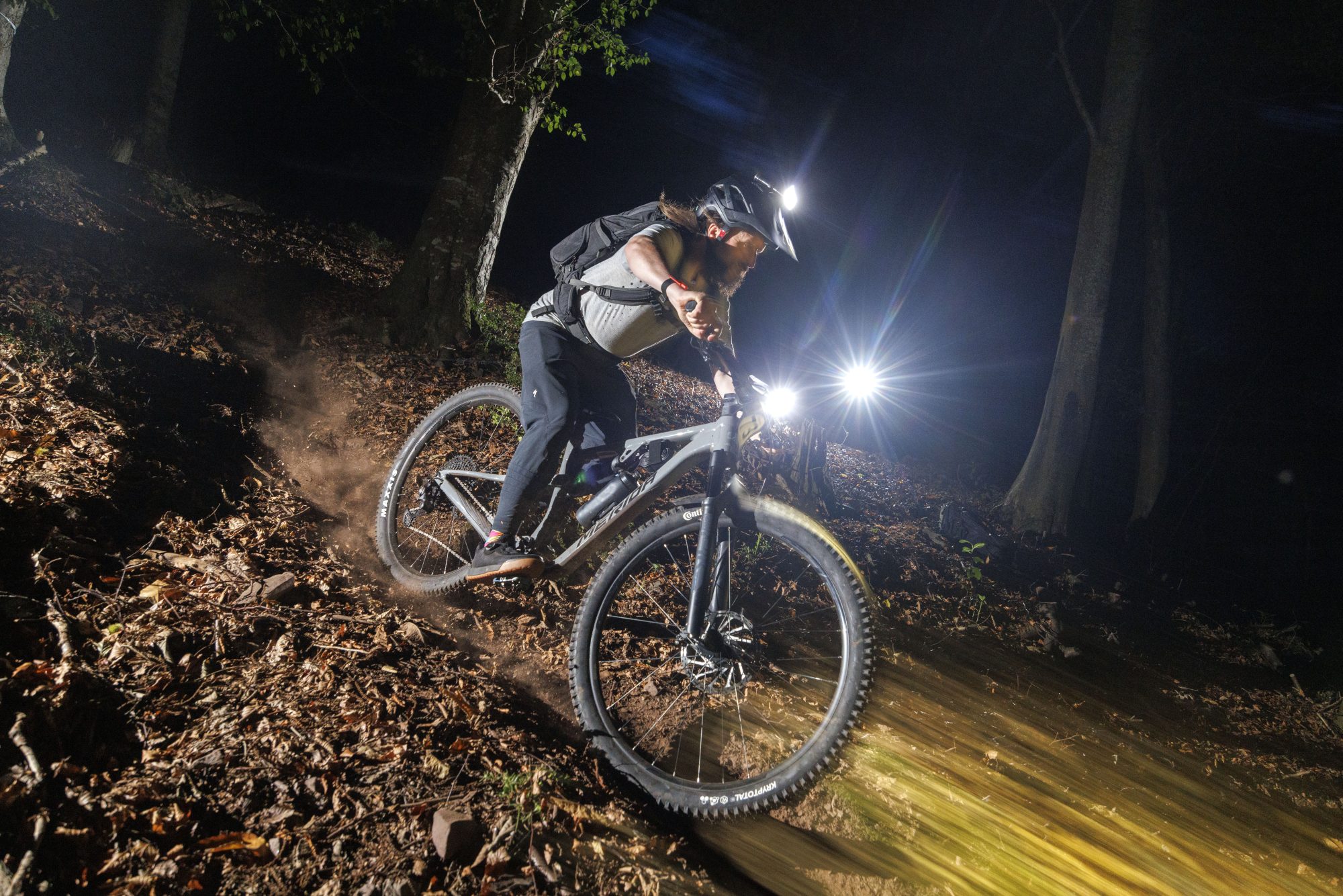 photo of a mountain bike rider at night using lights